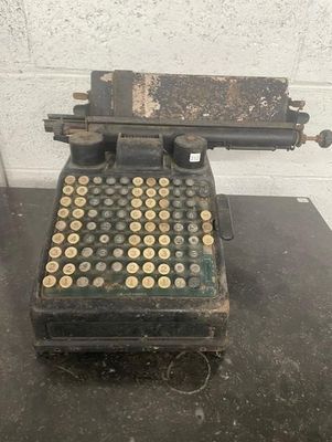 an old typewriter sitting on top of a table next to a brick wall