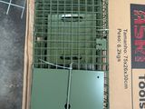 une cage à oiseaux posée par terre, avec un oiseau à l'intérieur