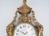 a gold clock that is hanging on the wall