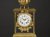 une image représentant une horloge dorée et noire posée sur une table blanche