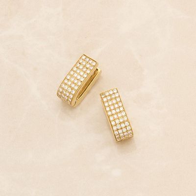a pair of gold earrings with diamonds on a marble surface