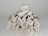 a white vase with a bird and flowers in it