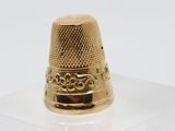 an image of a gold thimble sitting on top of a clear box