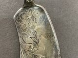 a silver spoon with a design on it on a table