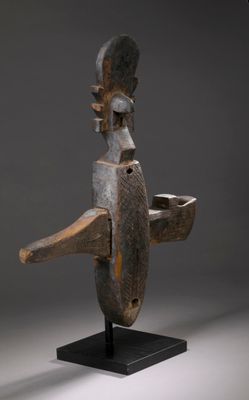 une image représentant une sculpture en bois d'un homme avec un oiseau sur la tête