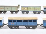 six petits trains miniatures alignés sur une surface blanche