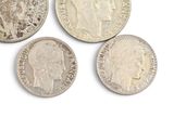 six different british silver coins on a white surface