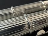 a silver pen that is laying on a black surface
