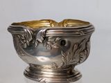 a silver bowl that has a gold decoration on it