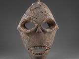 un gros plan d'un masque en bois représentant un visage