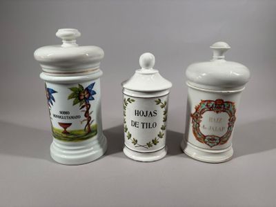 three white ceramic containers with designs on them sitting on a table