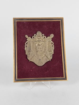 une image représentant une plaque métallique sur laquelle figure un blason