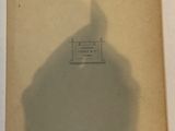 an old book with a shadow of a person standing in front of it