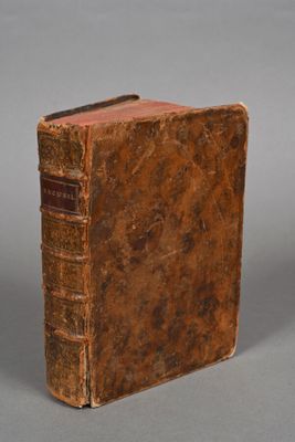 an old book sitting on top of a table next to a gray background