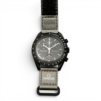 gros plan d'une montre sur une surface blanche avec un bracelet noir