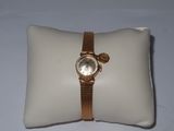 a watch on a pillow on a white surface