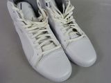 pair of white sneakers with white laces sitting on a white surface