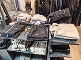 beaucoup de vêtements posés sur une étagère dans un magasin