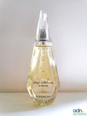 une photo en gros plan d'un flacon de parfum posé sur une table