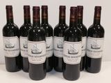 six bottles of red wine are lined up on a table