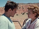 a man and a woman standing next to each other in the desert
