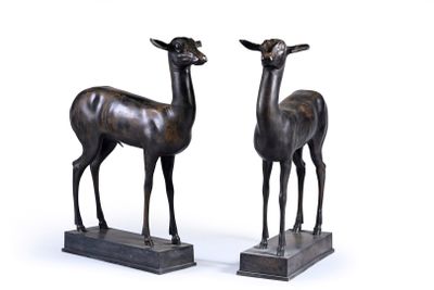 pair of bronze sculptures of a deer and a deer standing on a base