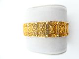 an image of a close up of a gold bracelet on a mannequin