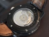 a close up of a watch on a brown surface