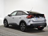 the rear end of a silver car in a white room