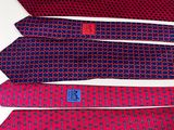 four ties are lined up on a white surface, one has a blue and red design on it