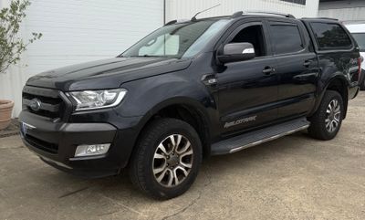 une photo d'un pick-up noir garé devant un immeuble