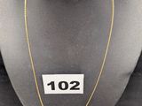 un collier et une bague présentés sur un mannequin