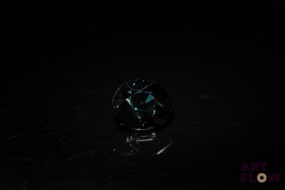un gros plan d'un diamant noir sur une surface noire