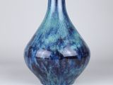 a blue vase that is sitting on a table