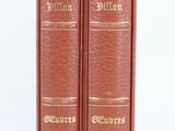 two red books sitting on top of each other on a white surface