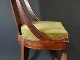 an old wooden chair with a green seat and a black background
