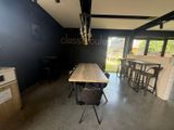 a table and chairs in a room with a black wall