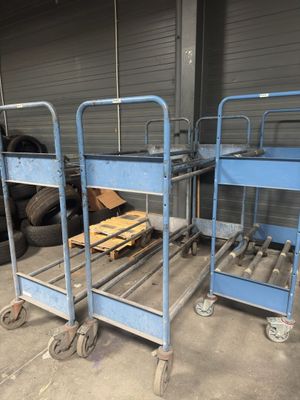 two blue metal beds sitting in a garage next to a pile of tires