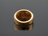 a close up of a gold ring sitting on top of a table