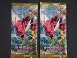 deux paquets de cartes à collectionner Pokémon posés sur une surface noire