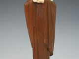 statue of a woman holding a child in her arms on top of a wooden base