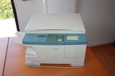 a printer that is sitting on a table in front of a window