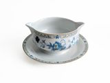 a white and blue bowl and saucer on a saucer