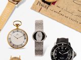 an assortment of watches and a certificate on a white surface