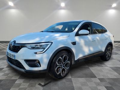 une voiture blanche est garée dans une pièce au sol à carreaux