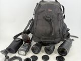 un sac à dos contenant un appareil photo, un objectif et d'autres objets