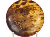 a tortoise shell plate with a floral design on it