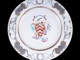 une assiette sur laquelle figure un blason sur fond noir