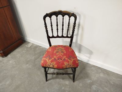 a small chair with a red seat in the corner of a room