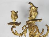 a gold colored candle holder with two flowers on it
